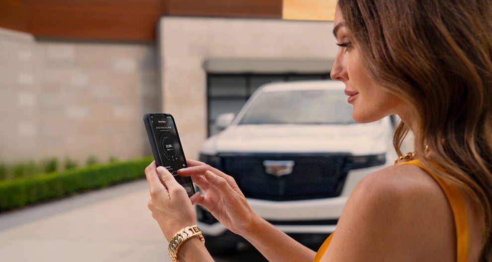 lady checking her mobile with a Cadillac vehicle background | Eagleson Automotive Center in Olney IL